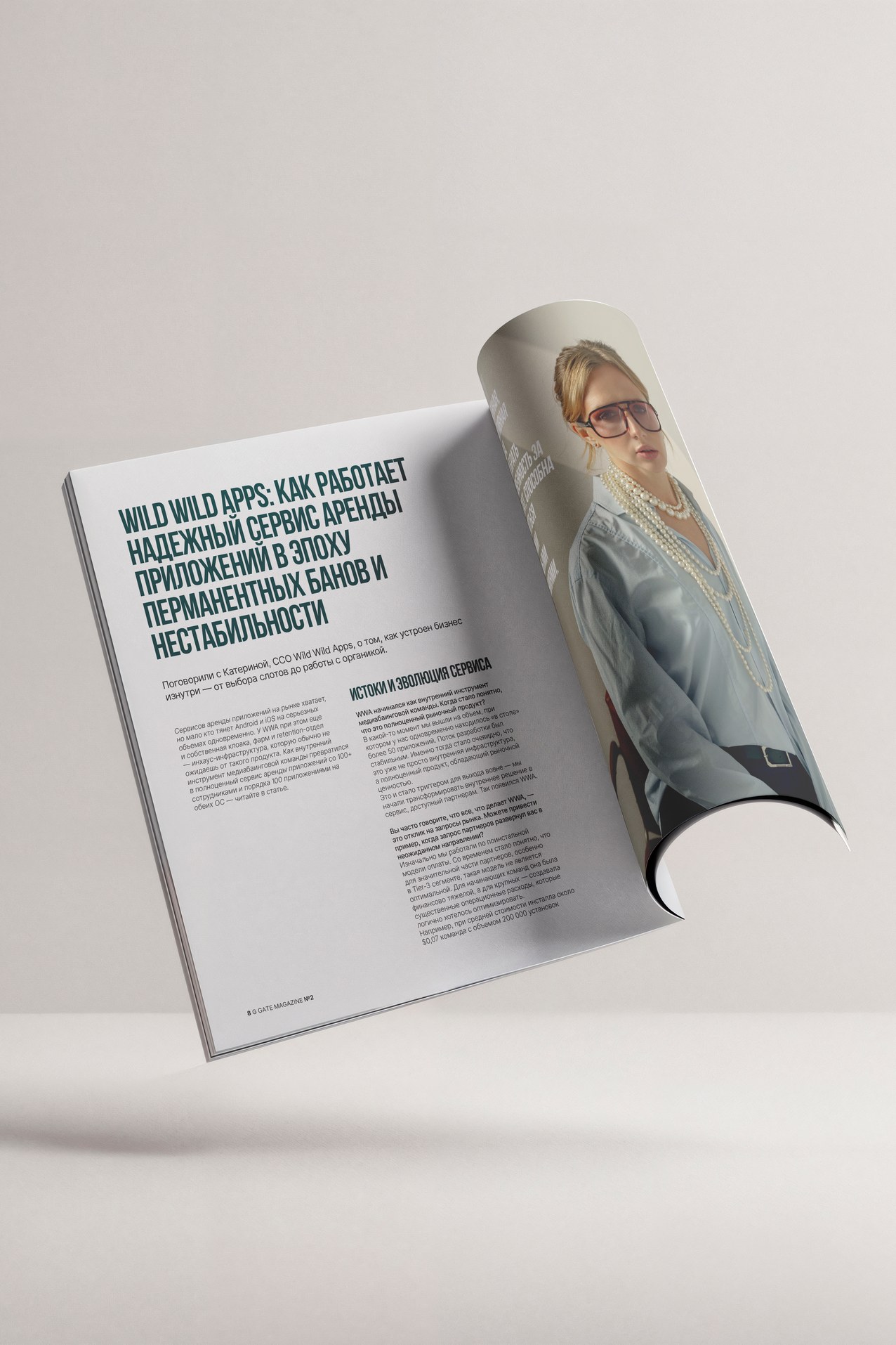 A copy of the magazine standing open with its front page curling, on warm grey
