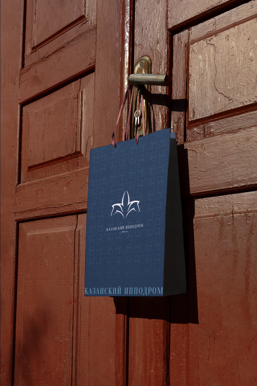 Navy paper bag with the tulip logo and wordmark hanging on a weathered red door