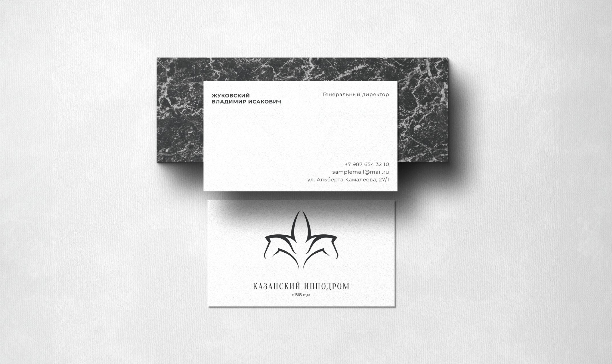 Business cards on grey marble — a black-marble director's card and a white card with the tulip logo