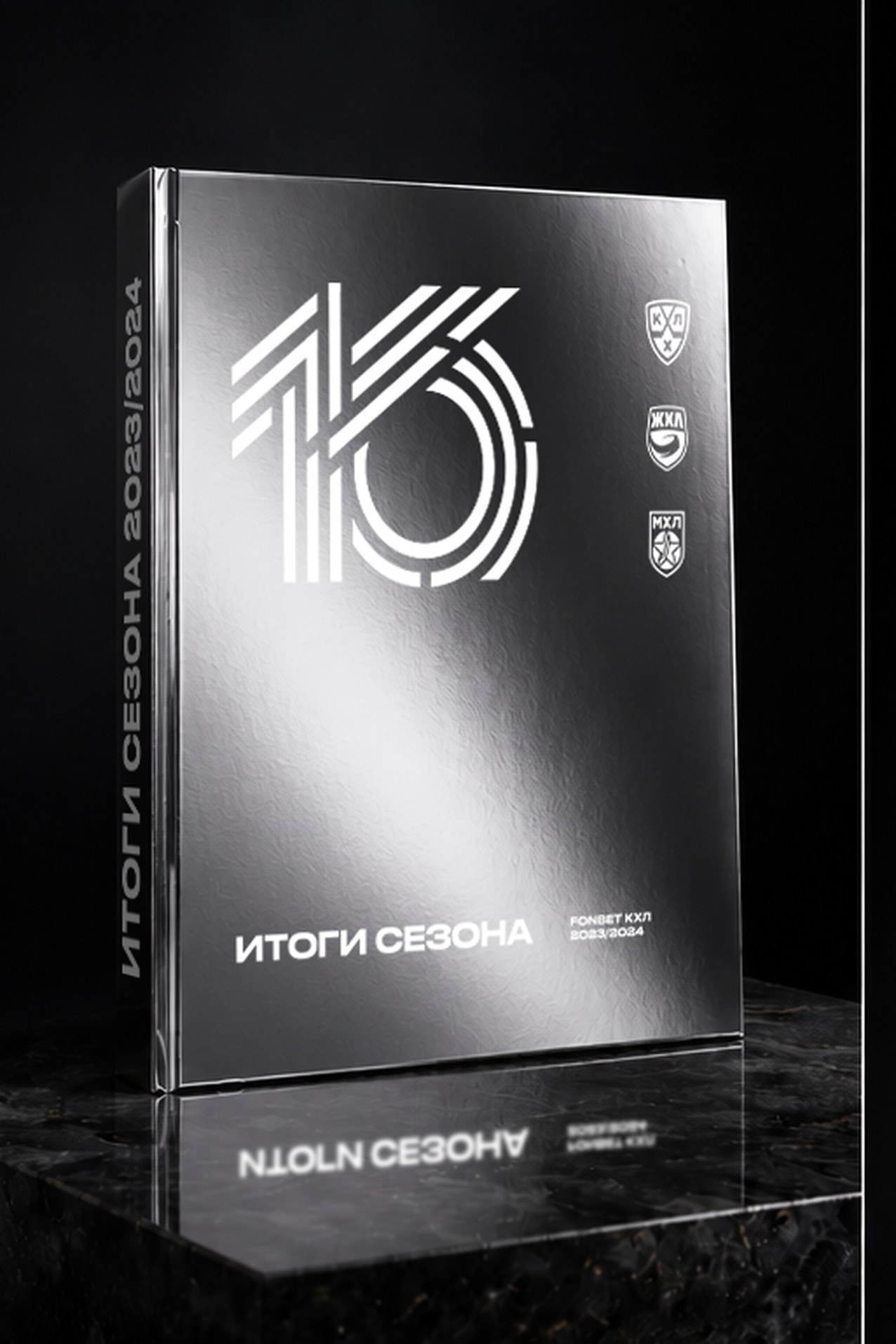 The KHL annual report standing on a dark reflective surface, silver "16 / ИТОГИ СЕЗОНА" cover facing the camera