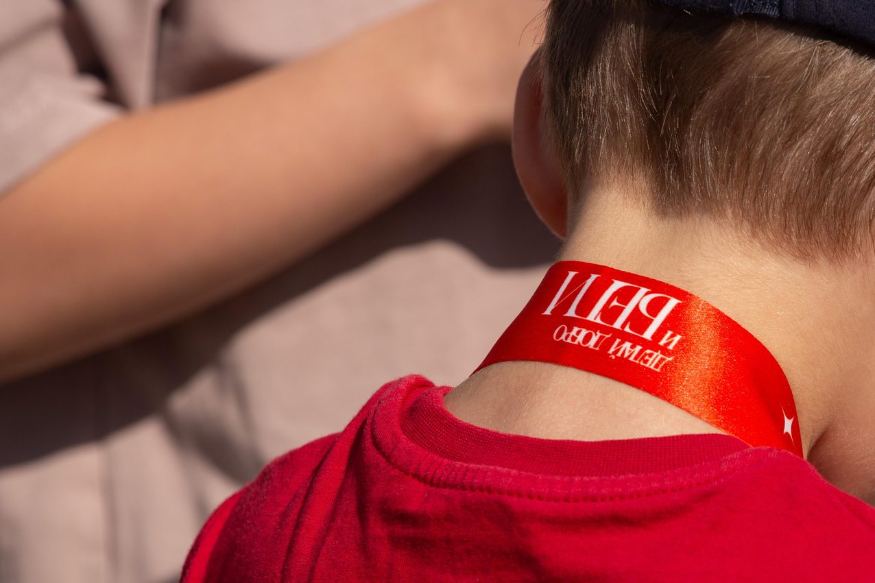 A finisher's red medal ribbon at the back of the neck