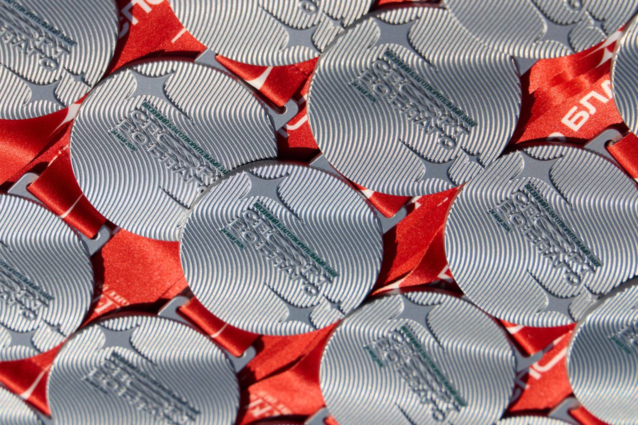 Rows of finisher medals with red ribbons
