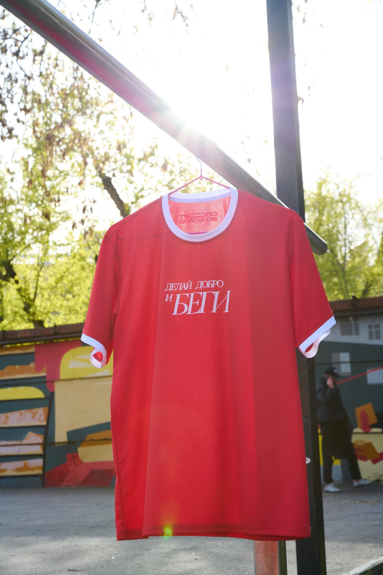 A red race shirt hanging outdoors on a pole